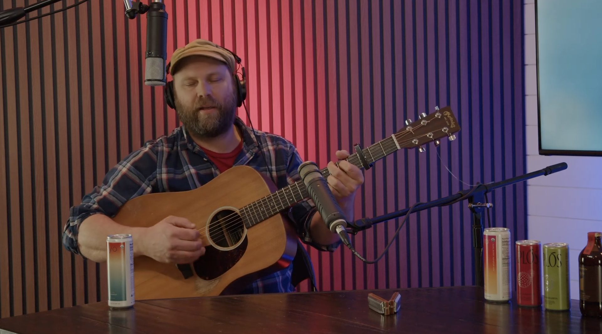 Musician recording guitar with headphones and studio microphone