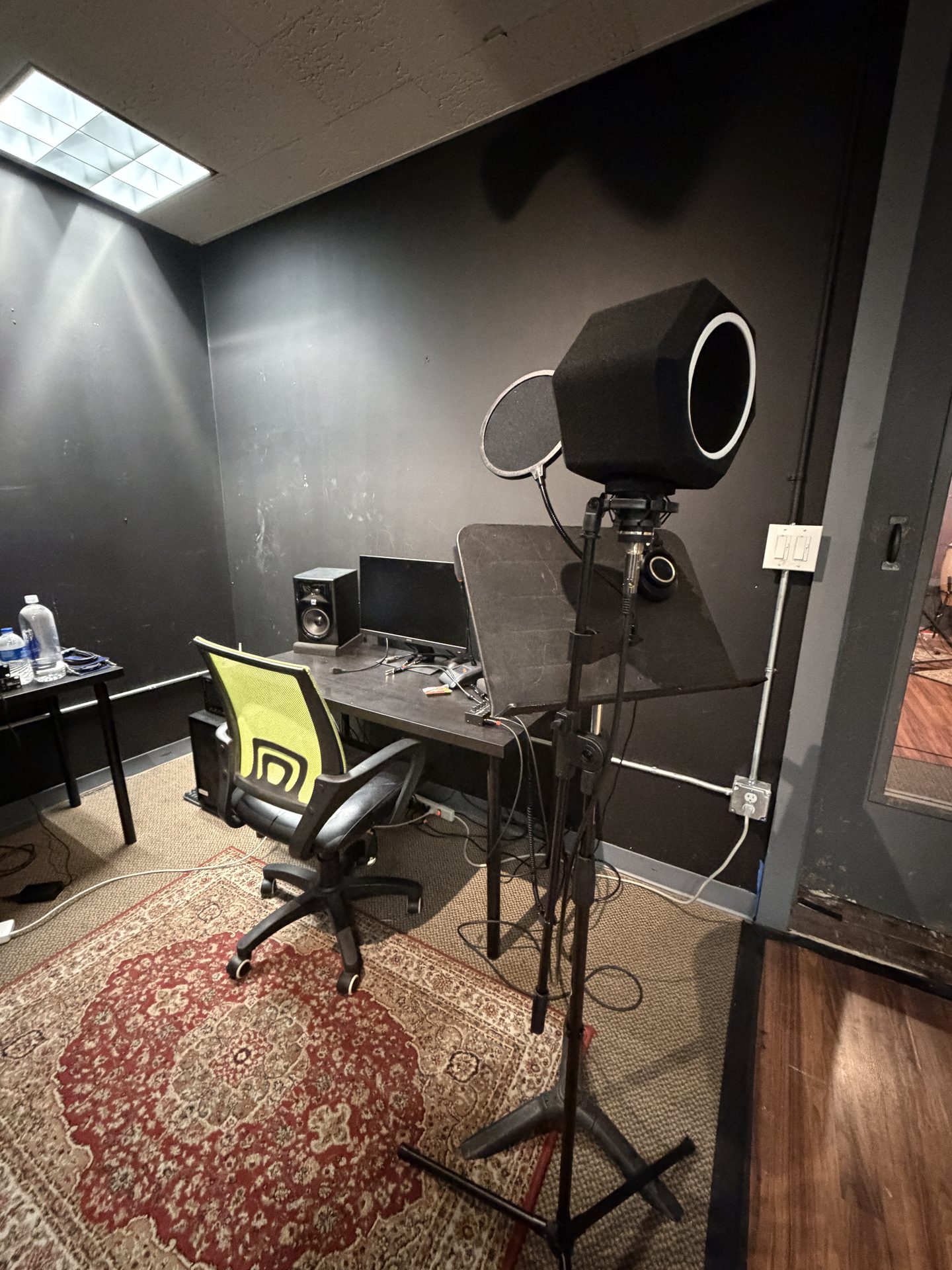 Professional audio recording booth with microphone, monitors, and speakers
